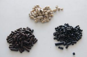 Ylhäällä vaaleaa teollisuuspellettiä, alhaalla mustaa pellettiä: höyrypellettiä (vasemmalla) ja paahtopellettiä.